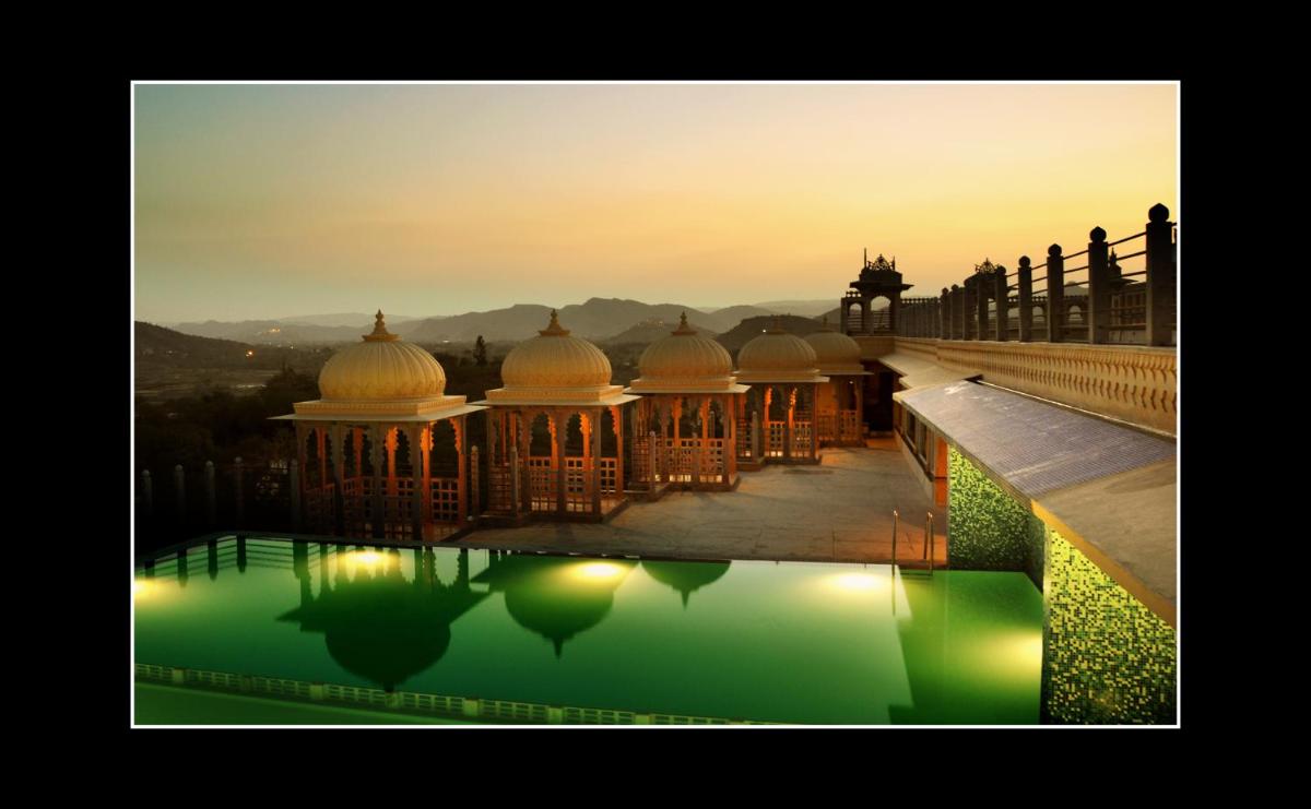 a view of a mosque in the water at sunset at Chunda Palace in Udaipur