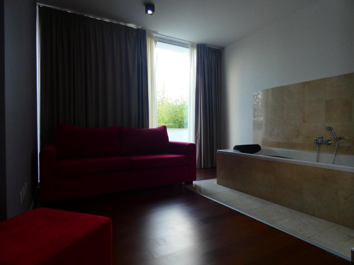 uma sala de estar com um sofá vermelho e uma banheira em Hotel Vila D'Óbidos em Óbidos