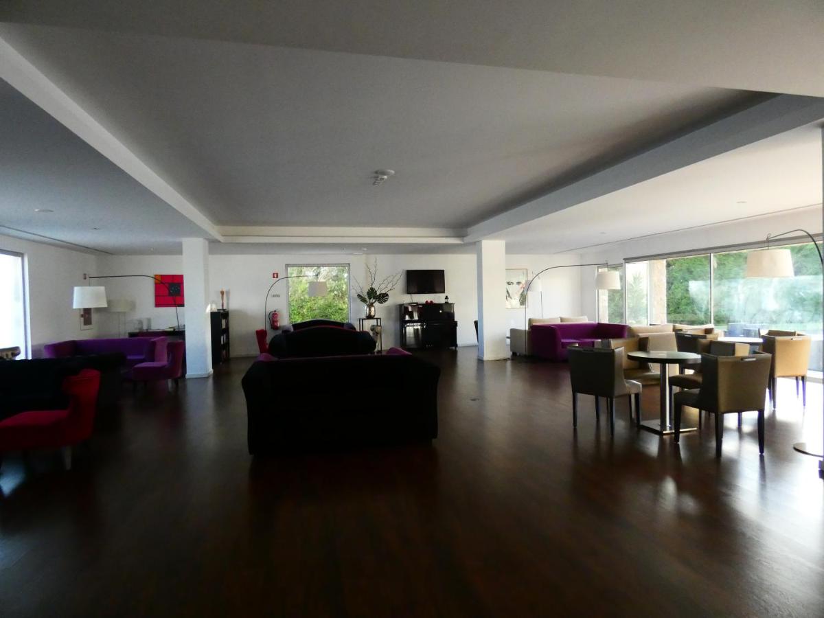 uma sala de estar com um sofá, uma mesa e cadeiras em Hotel Vila D'Óbidos em Óbidos