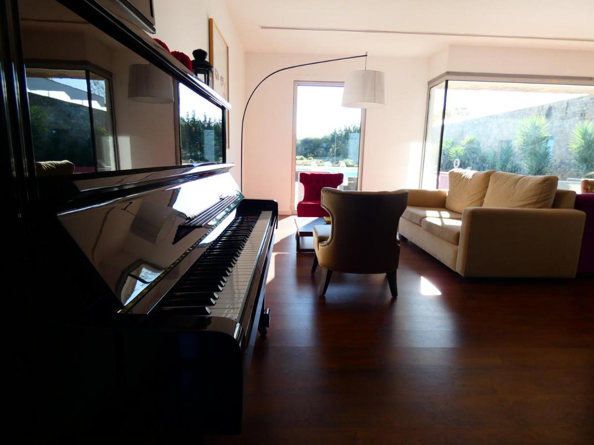 uma sala de estar com um piano e um sofá em Hotel Vila D'Óbidos em Óbidos