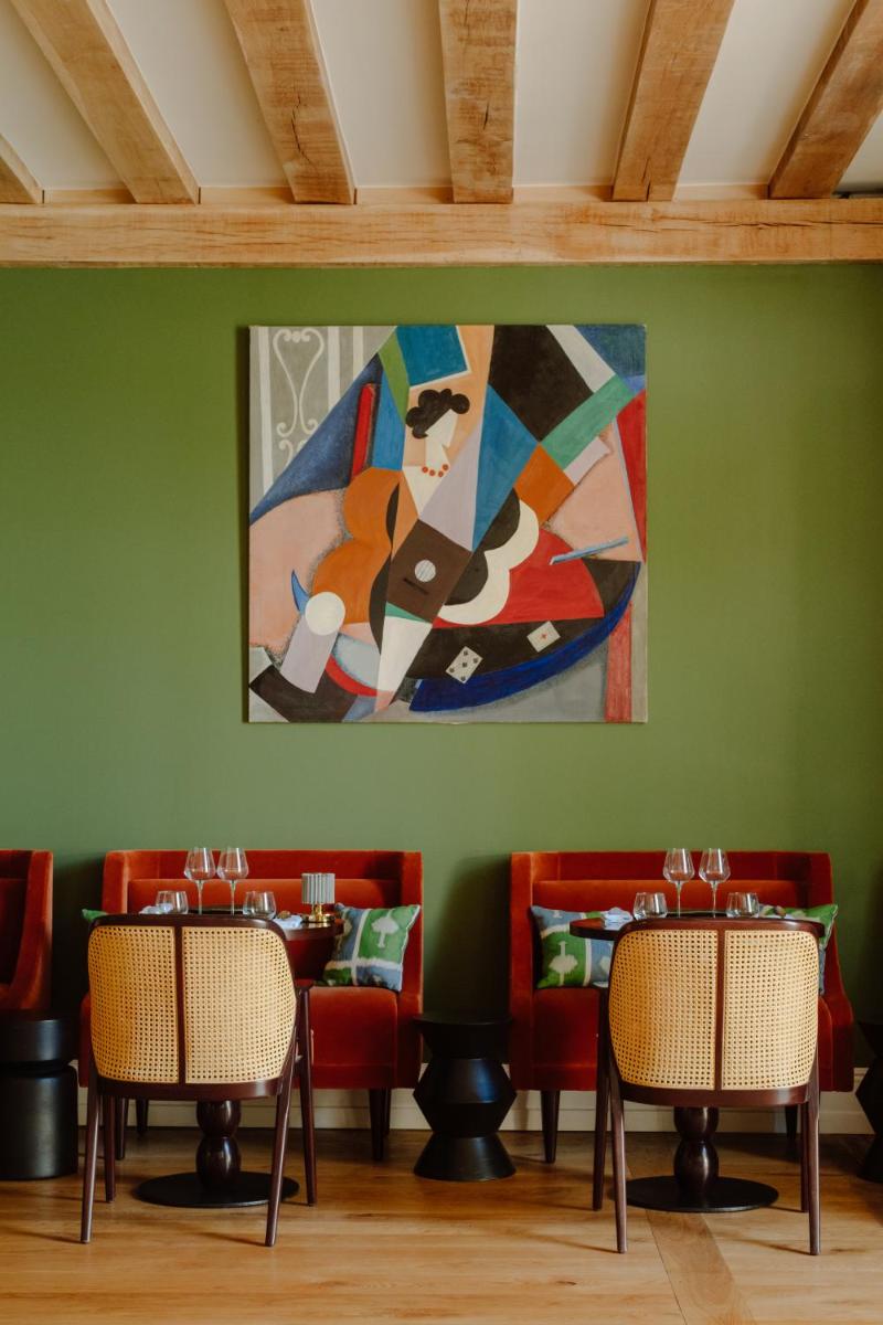 une salle à manger avec des chaises et un tableau mural dans l'établissement Hôtel Maison Pavlov - Restaurant & Spa - Bordeaux Bouscat, à Le Bouscat