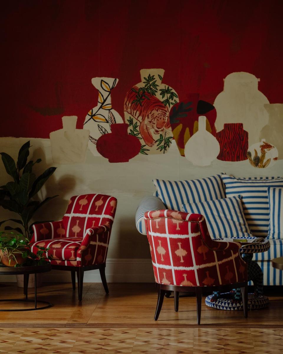 - un salon avec deux chaises et des murs rouges dans l'établissement Hôtel Maison Pavlov - Restaurant & Spa - Bordeaux Bouscat, à Le Bouscat