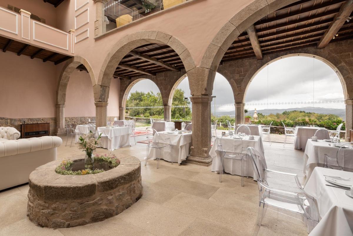 Un comedor con mesas blancas y sillas blancas. en Áurea Palacio de Sober by Eurostars Hotel Company, en Sober
