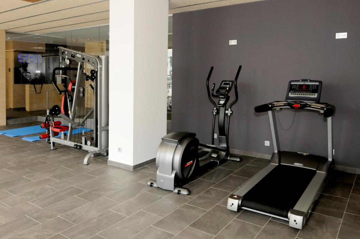 un gimnasio con varias cintas de correr y máquinas elípticas en Hotel Riviera, en Santa Susanna