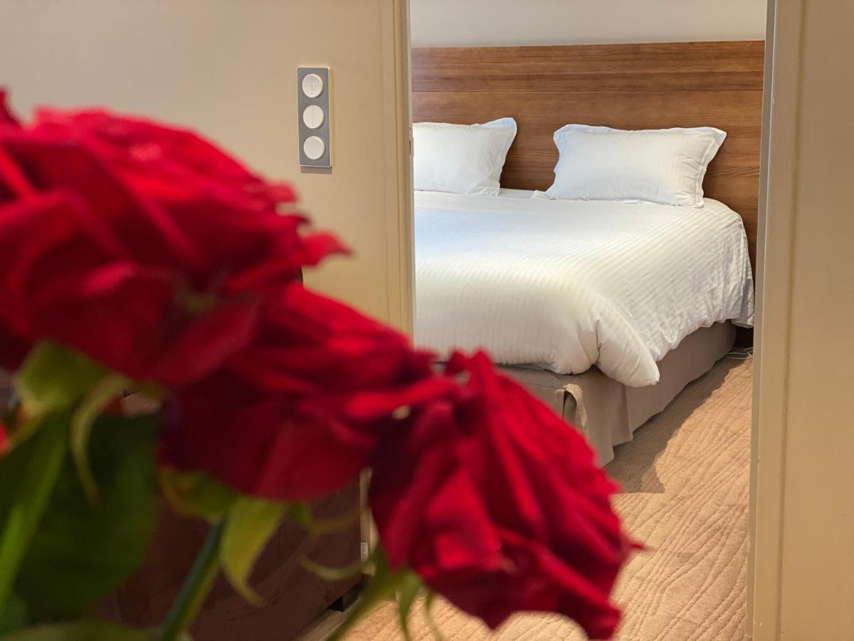 - une chambre avec une fleur rouge devant un miroir dans l'établissement Le 1837, à Saint-Affrique