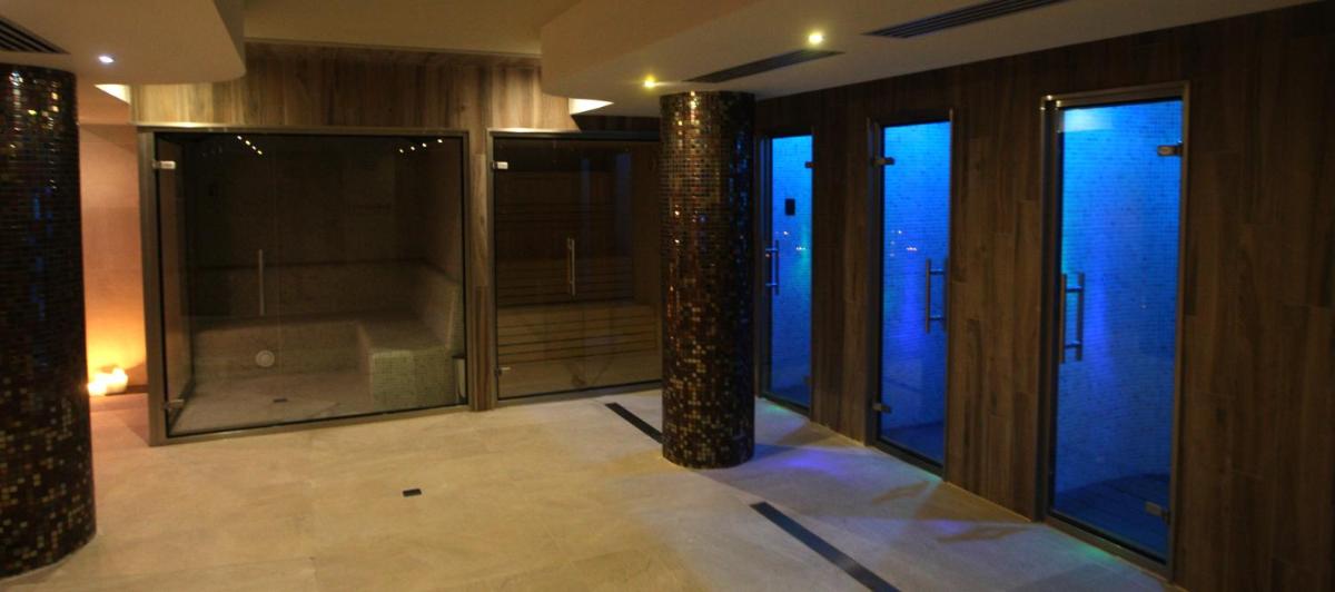 Habitación con grandes ventanas de cristal y un pilar. en Hotel & Spa Real Villa Anayet, en Canfranc-Estación