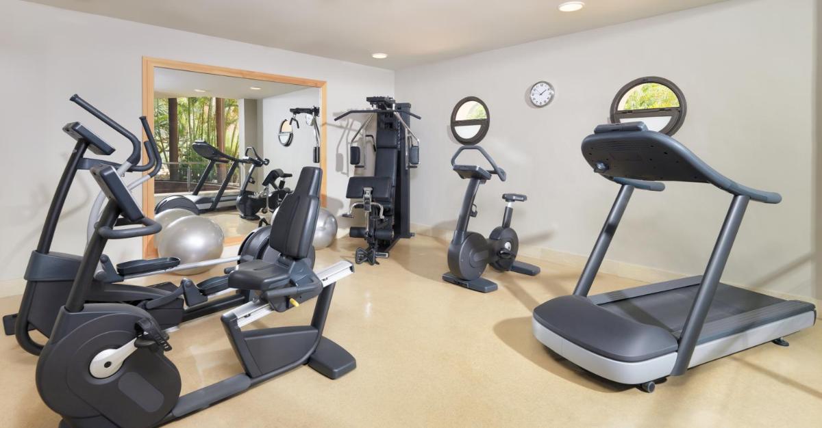 Un gimnasio con cintas de correr y elípticas en una habitación. en Hotel Las Madrigueras Golf Resort & Spa - Adults Only, en Playa de las Américas