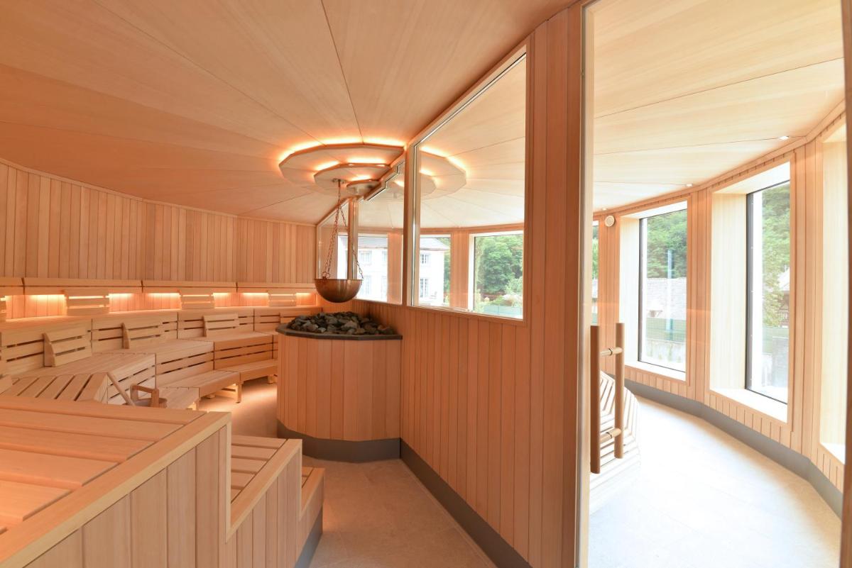 une salle de conférence avec bancs et fenêtres dans l'établissement 6717 Nature Hôtel & Spa Le Clos des Délices, à Ottrott