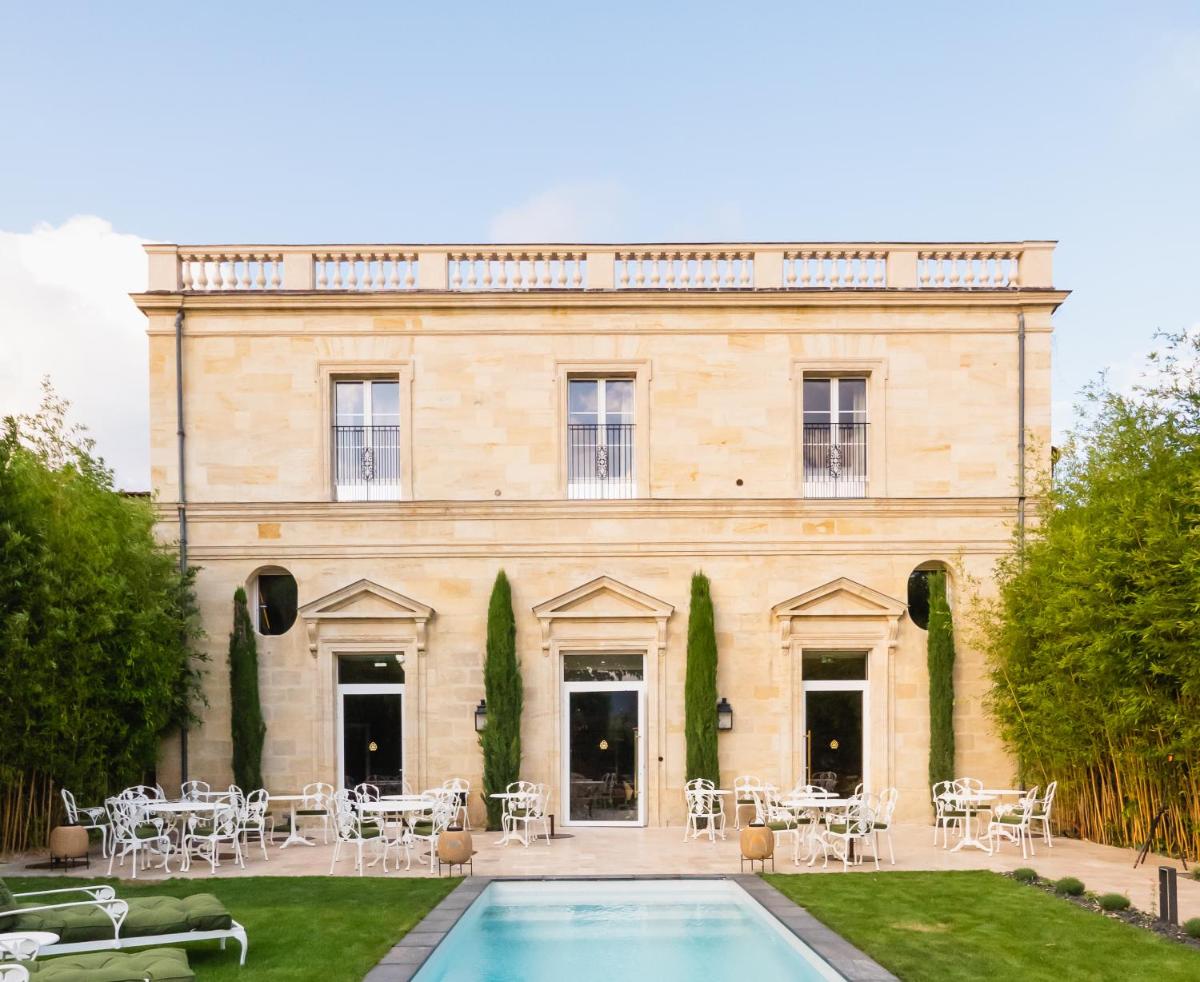 un bâtiment avec une piscine devant dans l'établissement Hôtel Maison Pavlov - Restaurant & Spa - Bordeaux Bouscat, à Le Bouscat