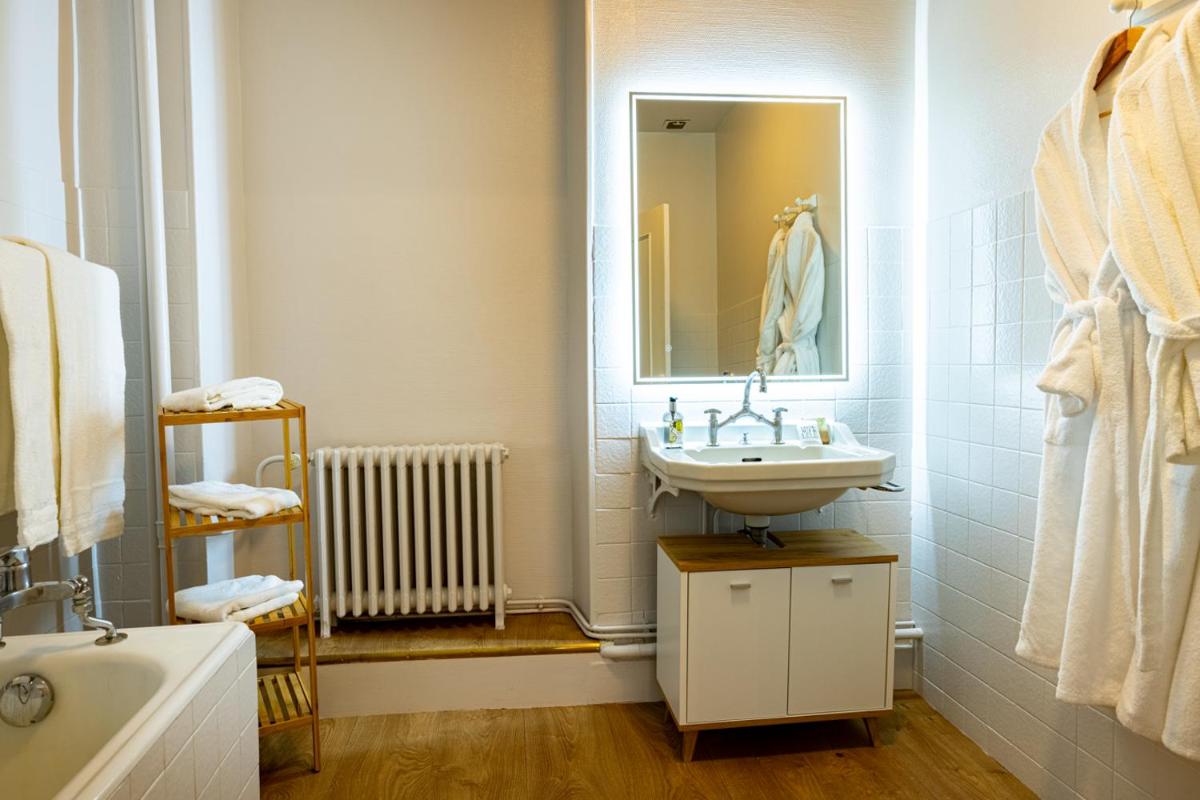 une salle de bain avec un lavabo et un miroir dans l'établissement Logis Relais de la Source, à Saint-Seine-lʼAbbaye