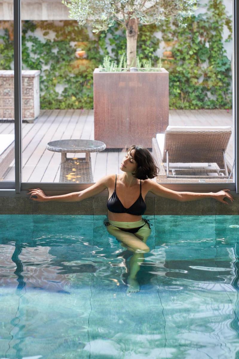 uma mulher está sentada em uma piscina em PortoBay Liberdade em Lisboa