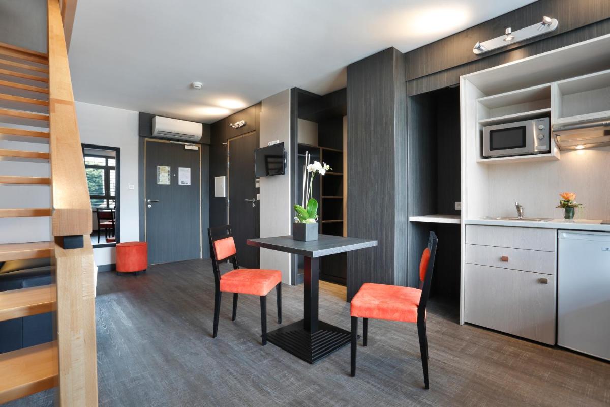 une cuisine et une salle à manger avec une table et des chaises dans l'établissement The Originals Boutique, Hôtel d'Alsace, Strasbourg Sud, à Illkirch-Graffenstaden