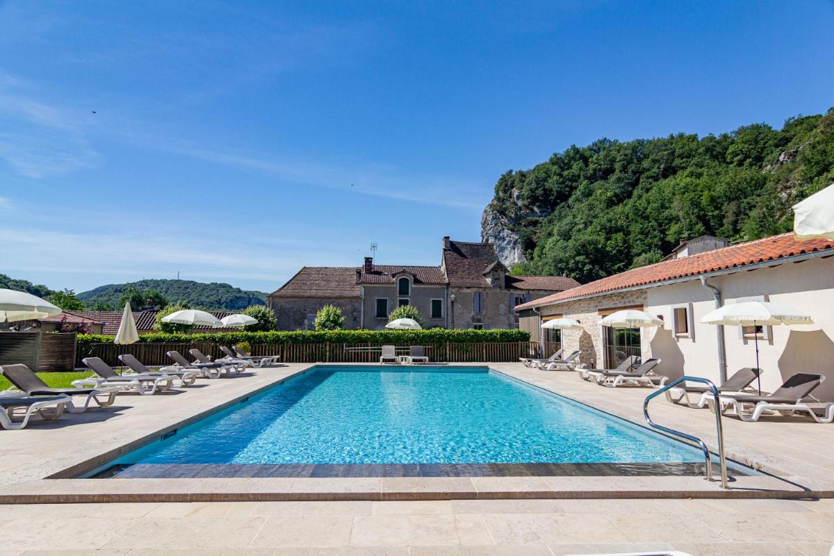 une piscine avec des chaises et une maison dans l'établissement Hôtel Spa La Truite Dorée, à Vers