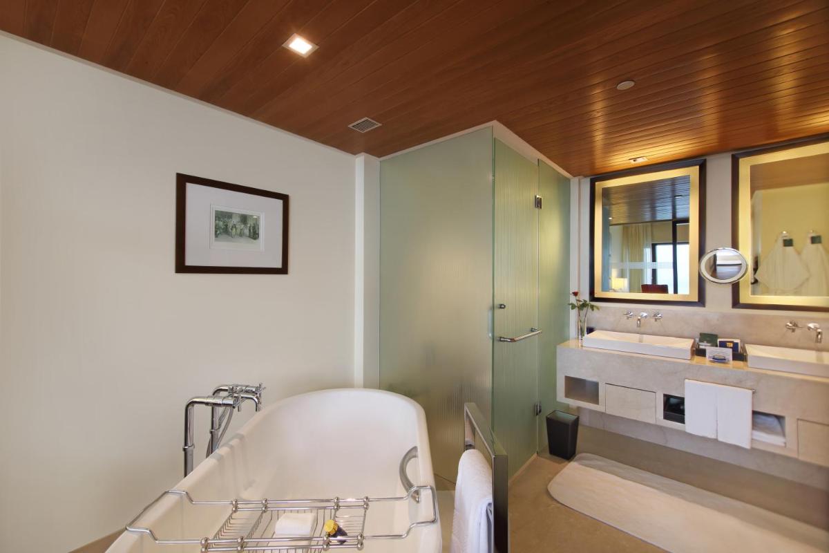 a bathroom with a tub and a sink and a mirror at The Oberoi Mumbai in Mumbai