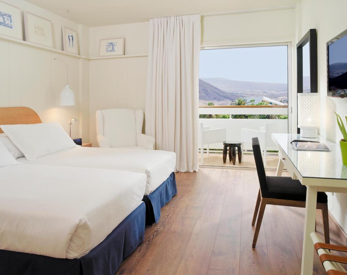Una habitación de hotel con una cama, una mesa y un escritorio. en Boutique Hotel H10 Big Sur - Adults Only, en Los Cristianos