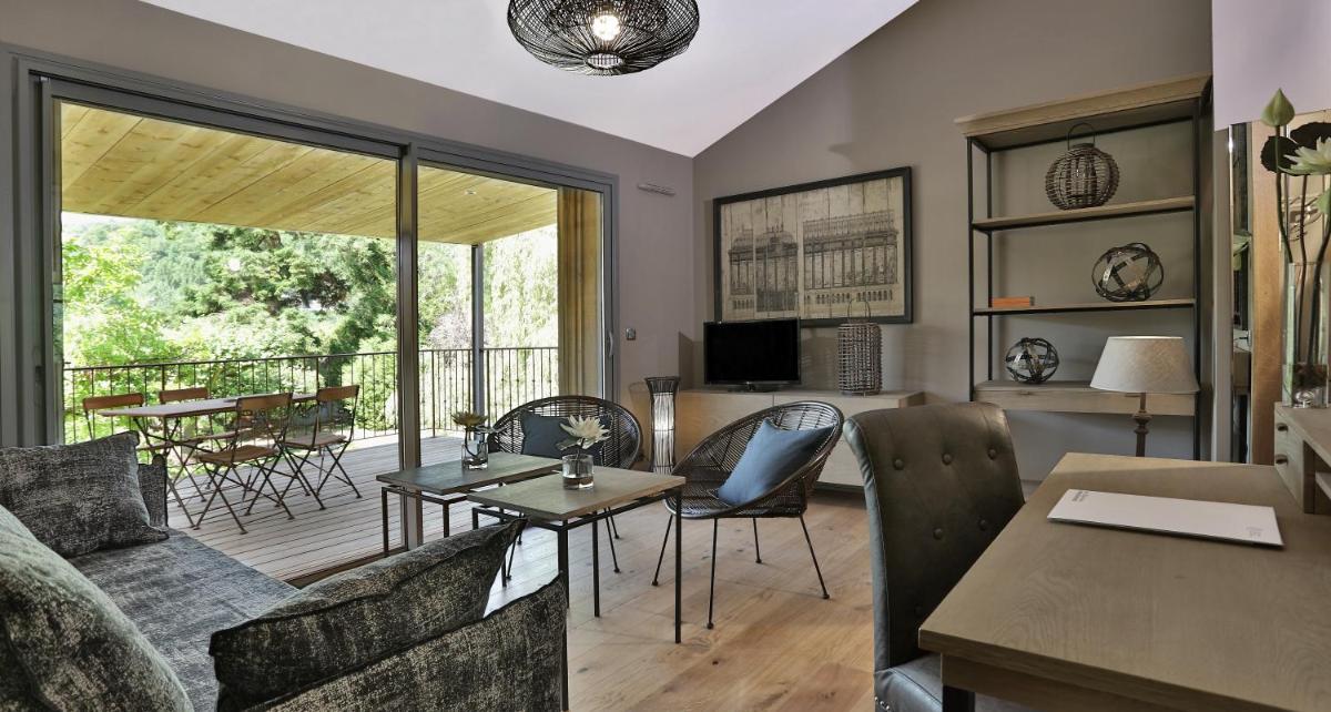 un salon avec un canapé et une table dans l'établissement Les Glycines - Hôtel & Spa - Teritoria, à Les Eyzies-de-Tayac