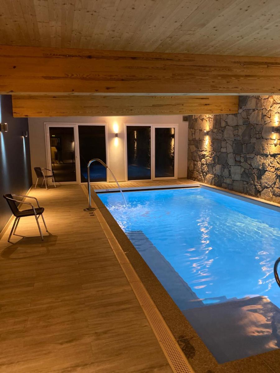 une piscine dans une maison avec un mur en pierre dans l'établissement Les Reflets du Lac, à Gérardmer