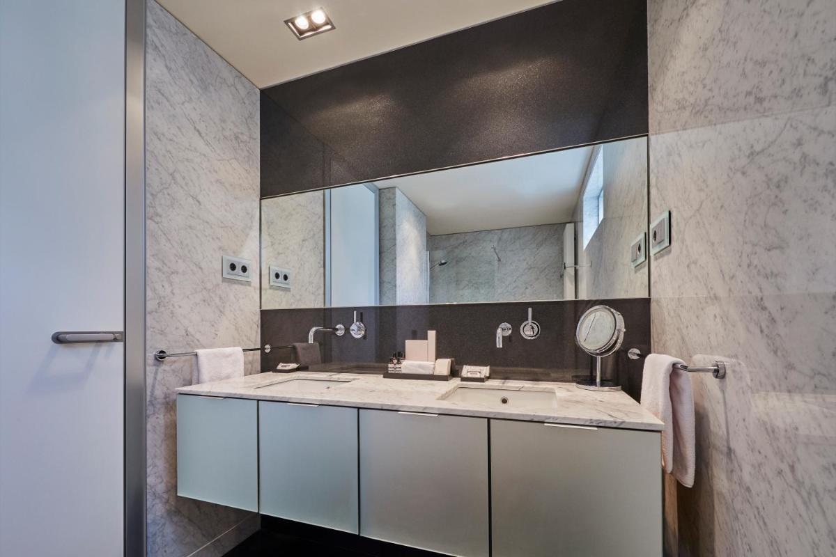 un baño con lavabo y espejo en Hyatt Regency Madrid Residences, en Madrid
