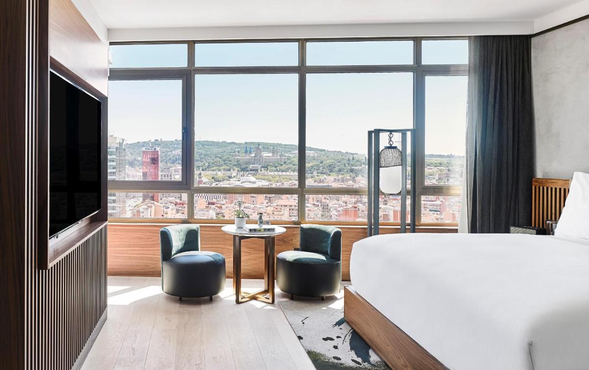 Una habitación de hotel con una cama y una ventana grande. en Nobu Hotel Barcelona, en Barcelona