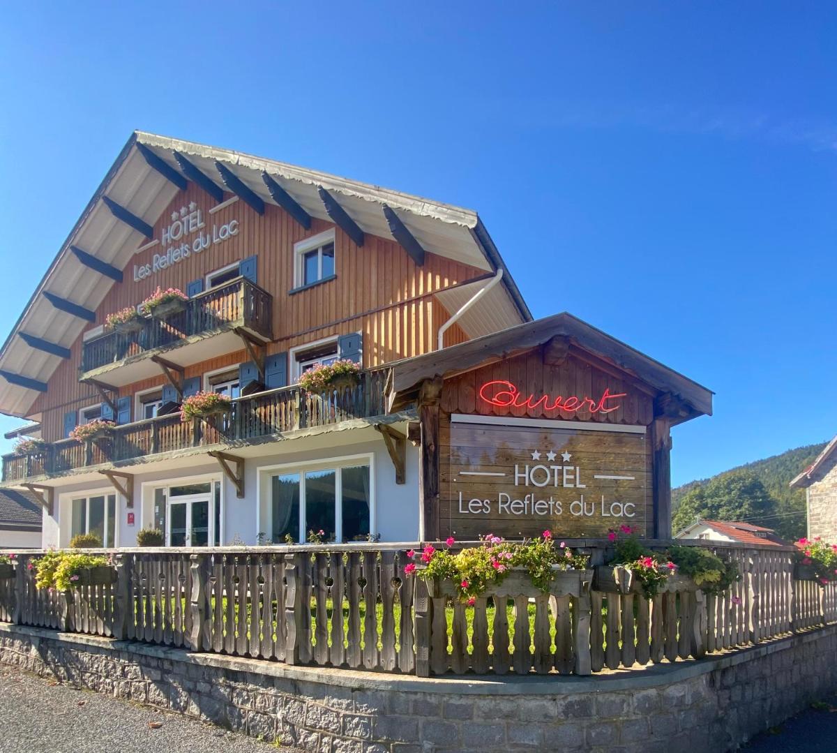 un bâtiment avec une clôture devant dans l'établissement Les Reflets du Lac, à Gérardmer