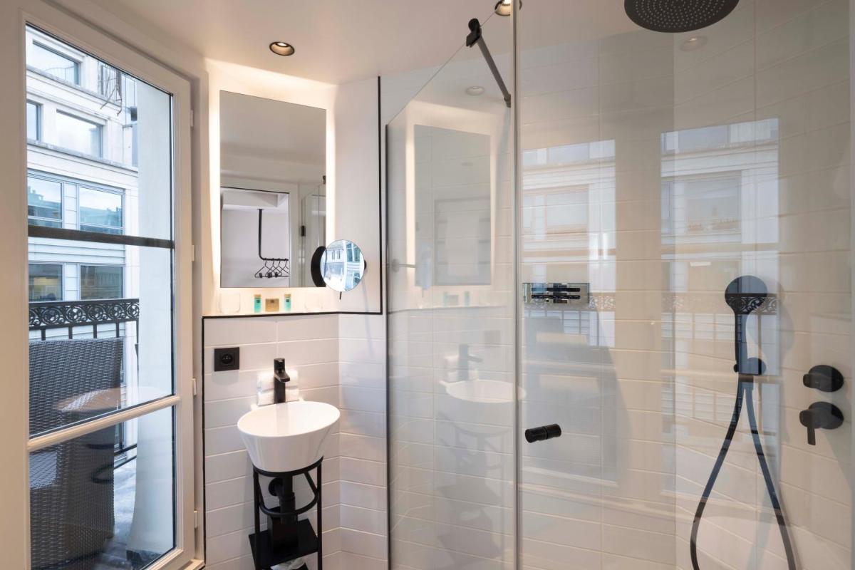une salle de bain avec une douche en verre avec un lavabo dans l'établissement Le 12 Hôtel, à Paris 56 autres photos
