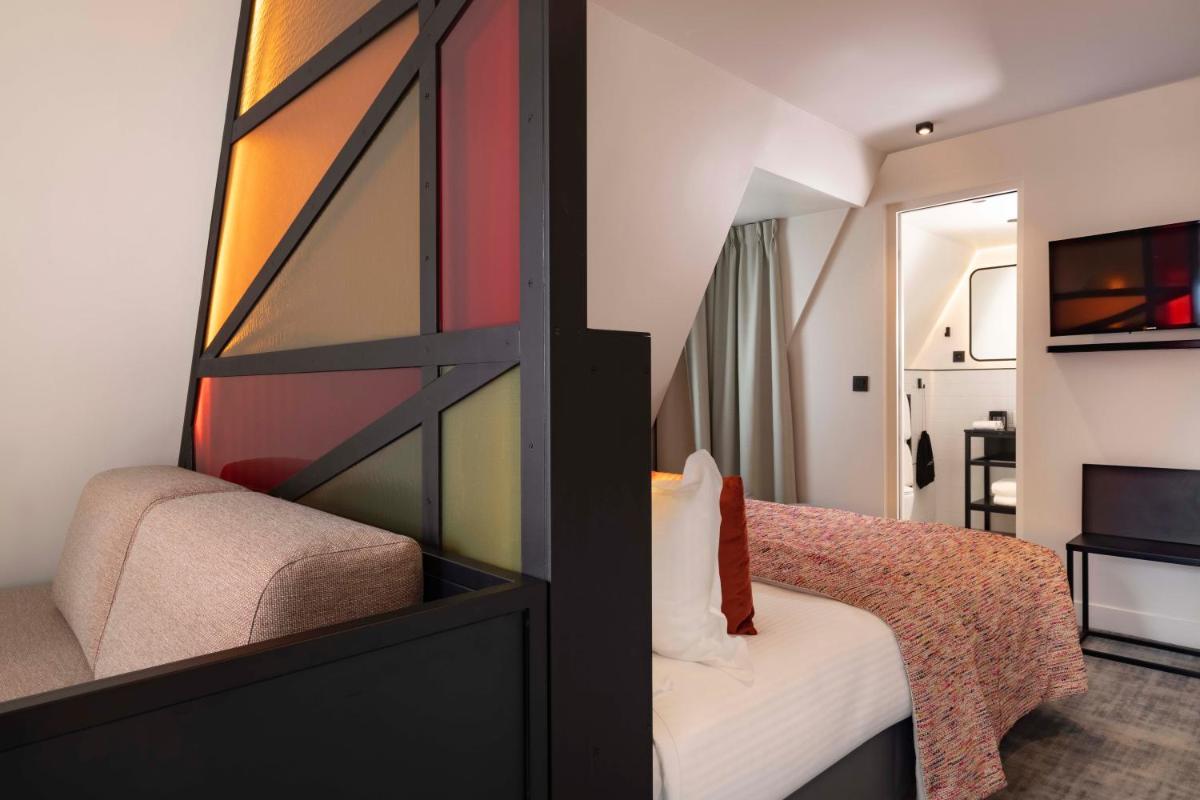 Un ou plusieurs lits dans un hébergement de l'établissement Le 12 Hôtel