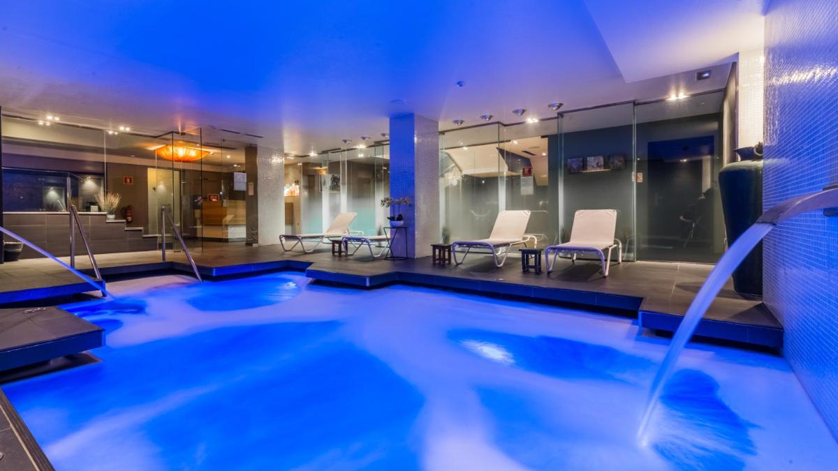 una piscina en un hotel con sillas y mesas en Grums Hotel & Spa, en Barcelona