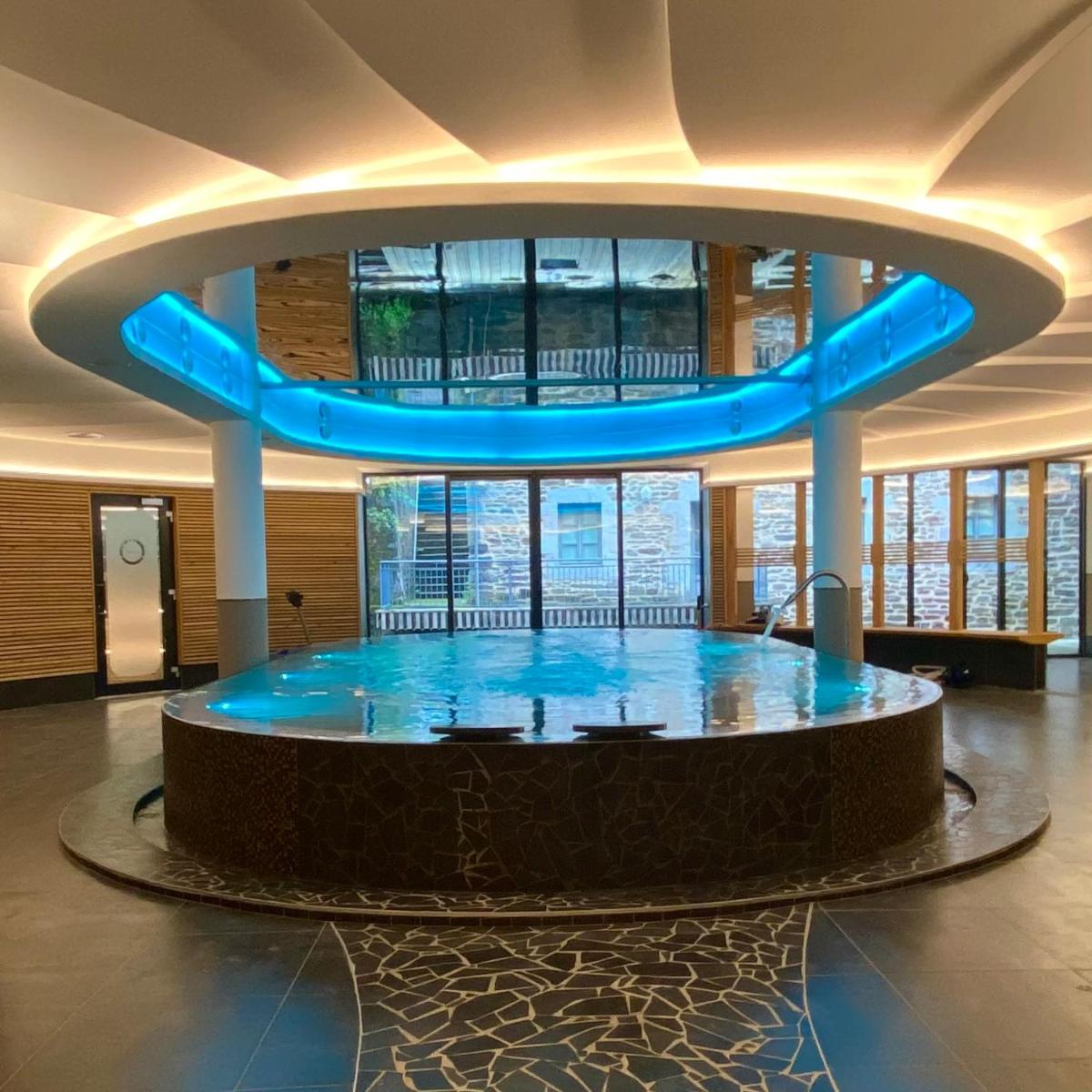 une grande salle avec une grande exposition bleue dans un bâtiment dans l'établissement Coin d'Aubrac Hôtel Restaurant SPA de luxe, à Chaudes-Aigues
