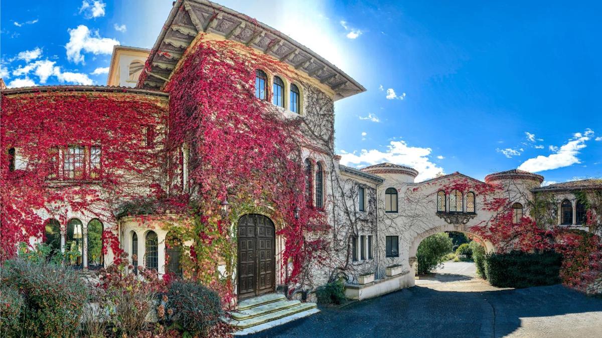 un domaine avec du lierre rouge sur le côté d'un bâtiment dans l'établissement Brindos, Lac & Château - Relais & Châteaux - Anglet Biarritz, à Anglet