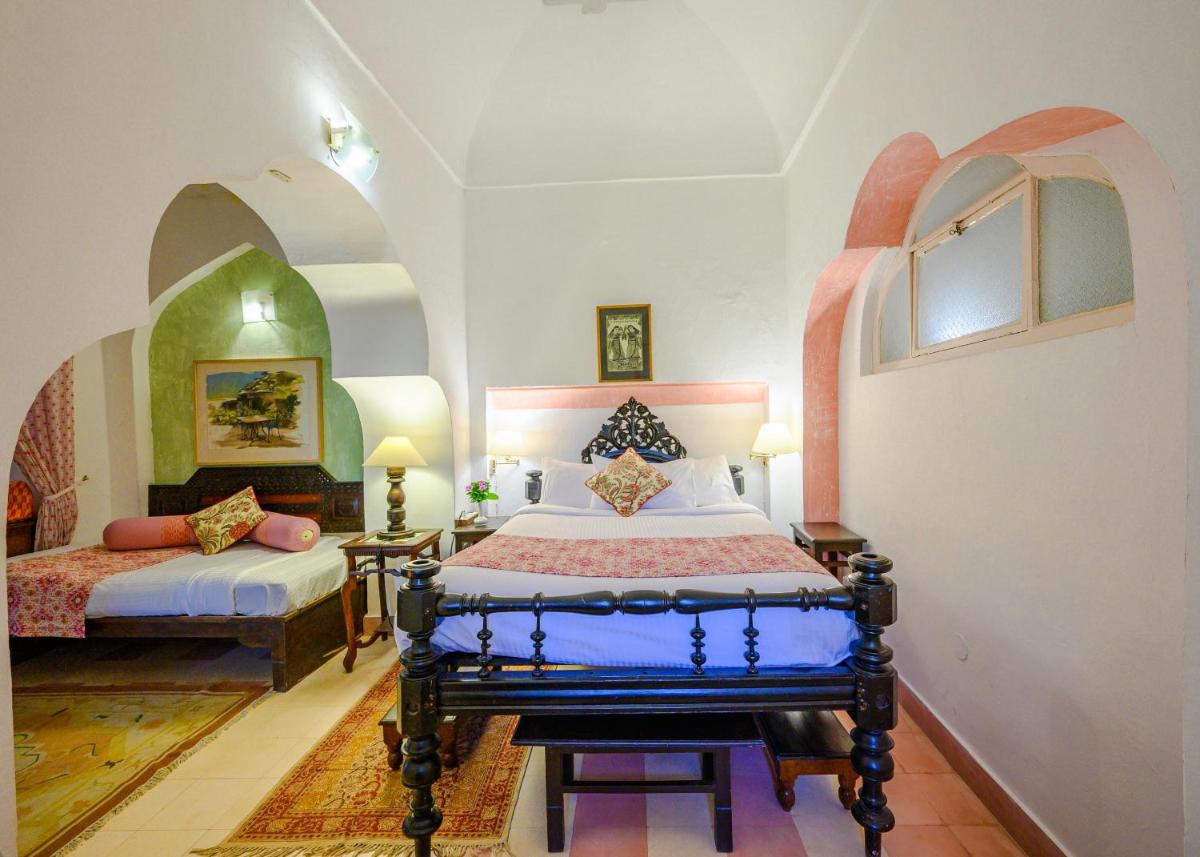 a bedroom with two beds in a room at Neemrana Fort-Palace in Neemrana