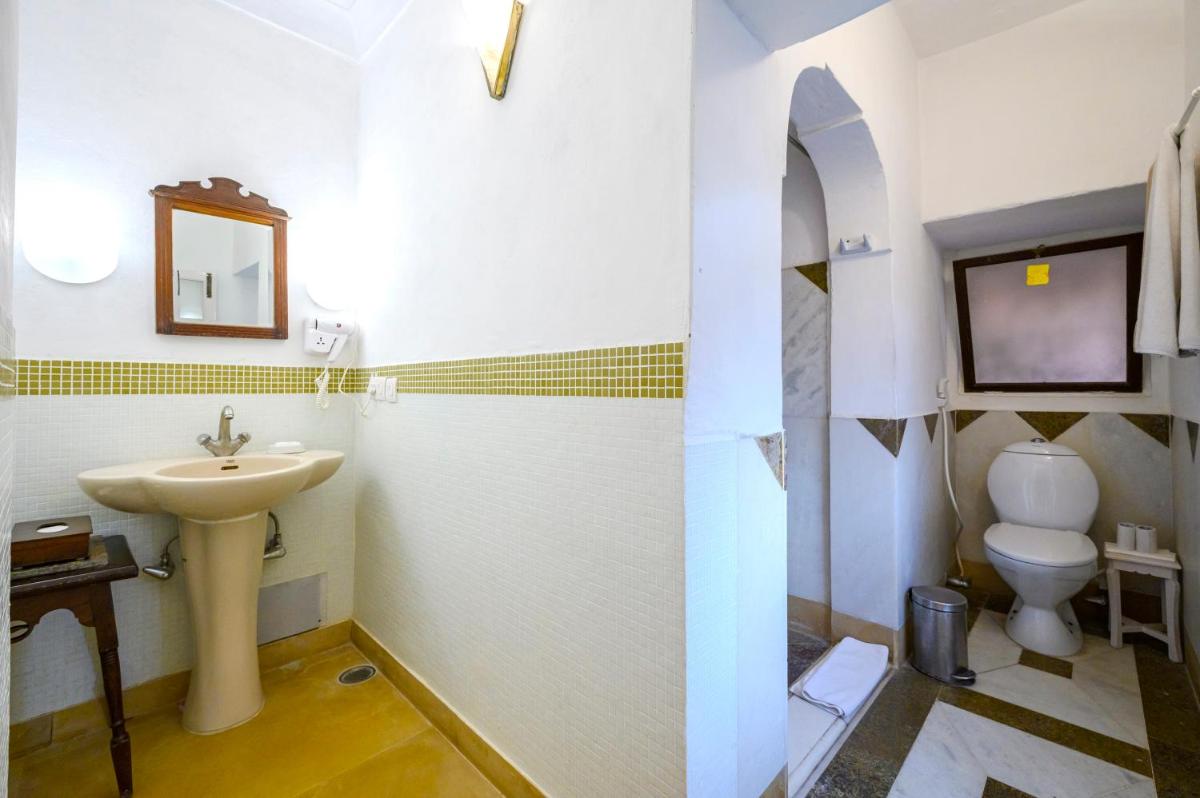 a bathroom with a sink and a toilet at Neemrana Fort-Palace in Neemrana