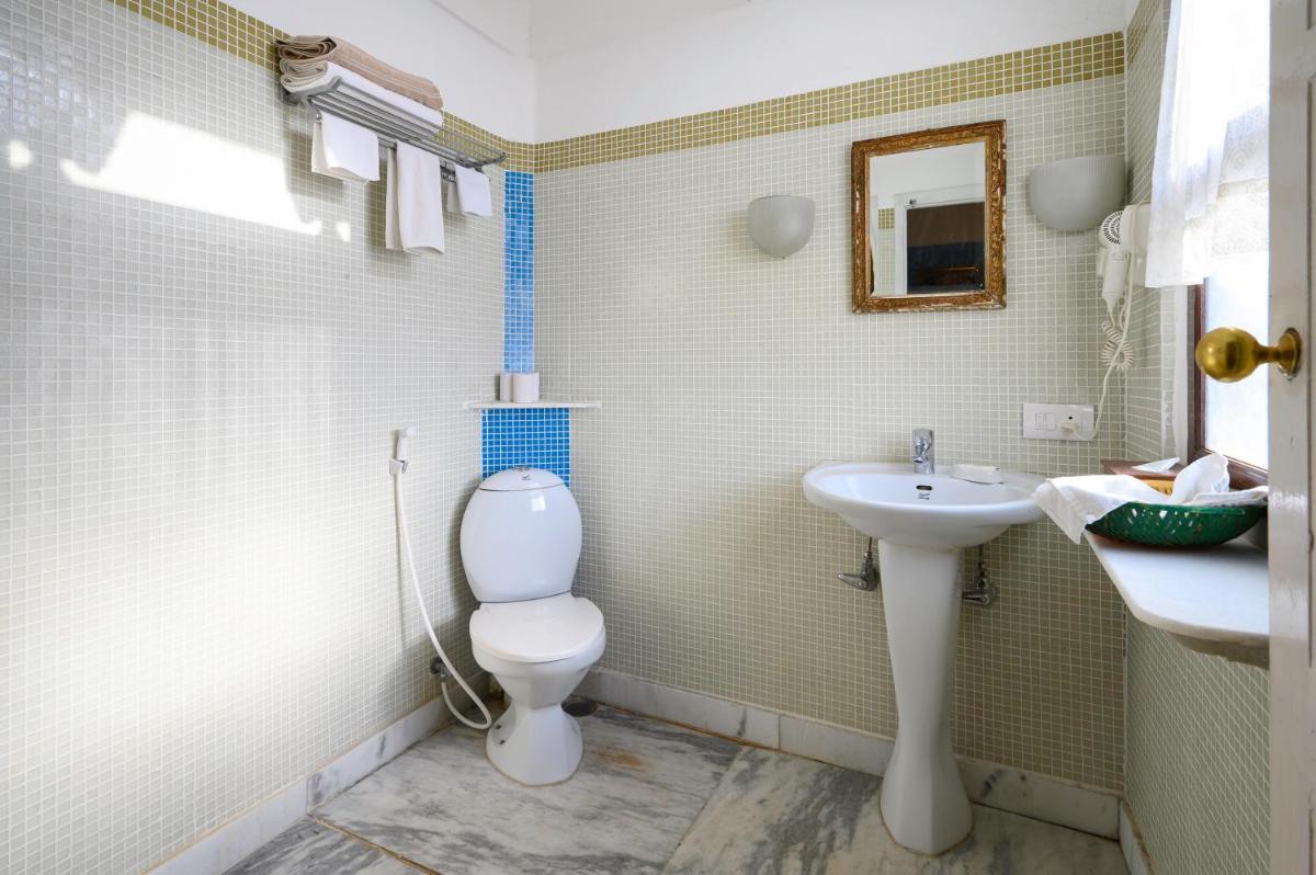 a bathroom with a toilet and a sink at Neemrana Fort-Palace in Neemrana