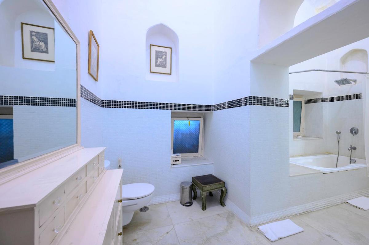 a white bathroom with a sink and a toilet at Neemrana Fort-Palace in Neemrana