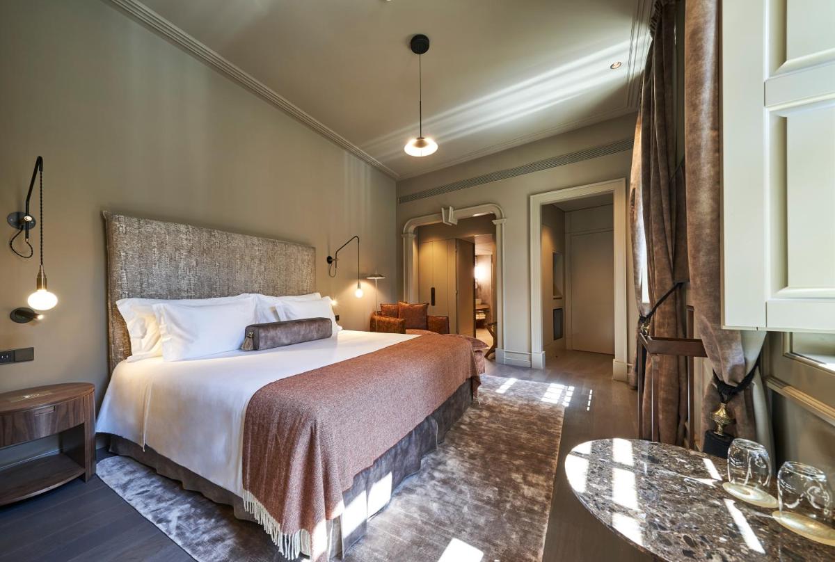 um quarto de hotel com uma cama e uma mesa em PortoBay Flores no Porto