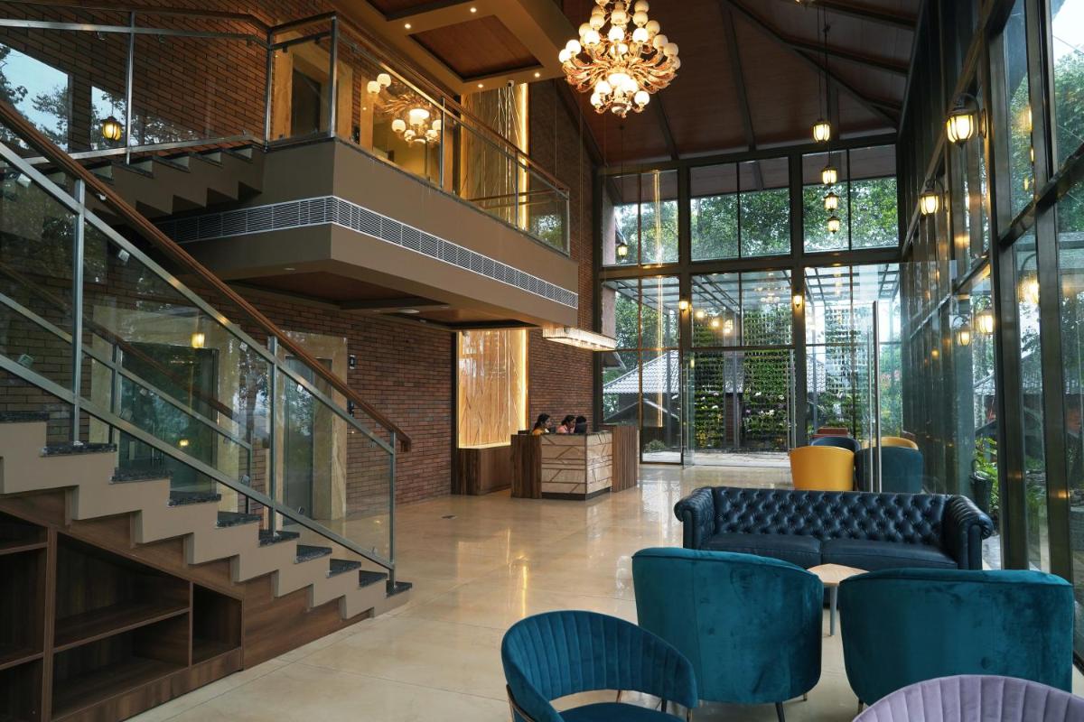 a lobby with blue chairs and a staircase at Elephant Passage in Munnar