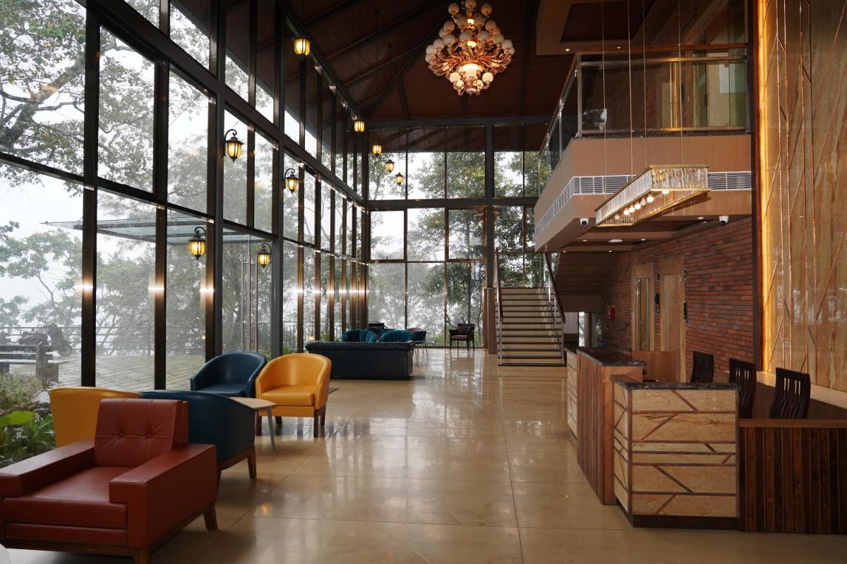 a lobby with couches and chairs and a chandelier at Elephant Passage in Munnar
