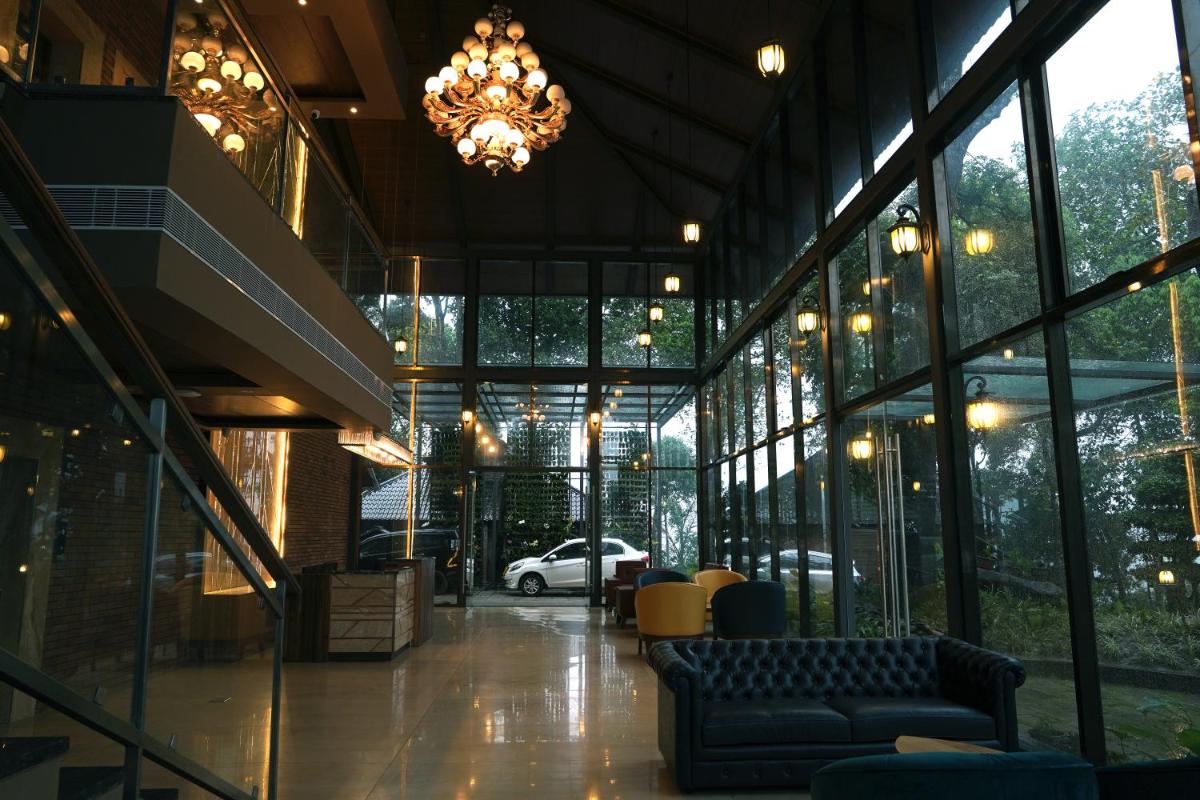 a lobby with a chandelier and a couch in a building at Elephant Passage in Munnar