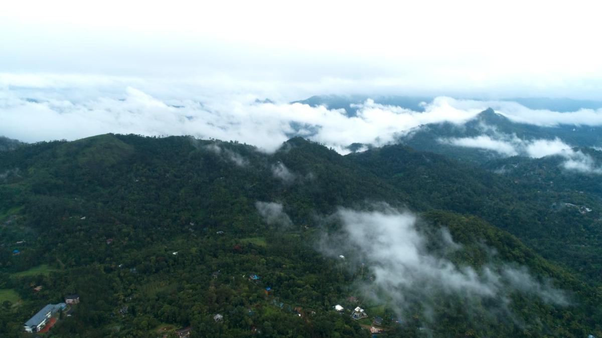 an aerial view of a mountain covered in clouds at Elephant Passage in Munnar