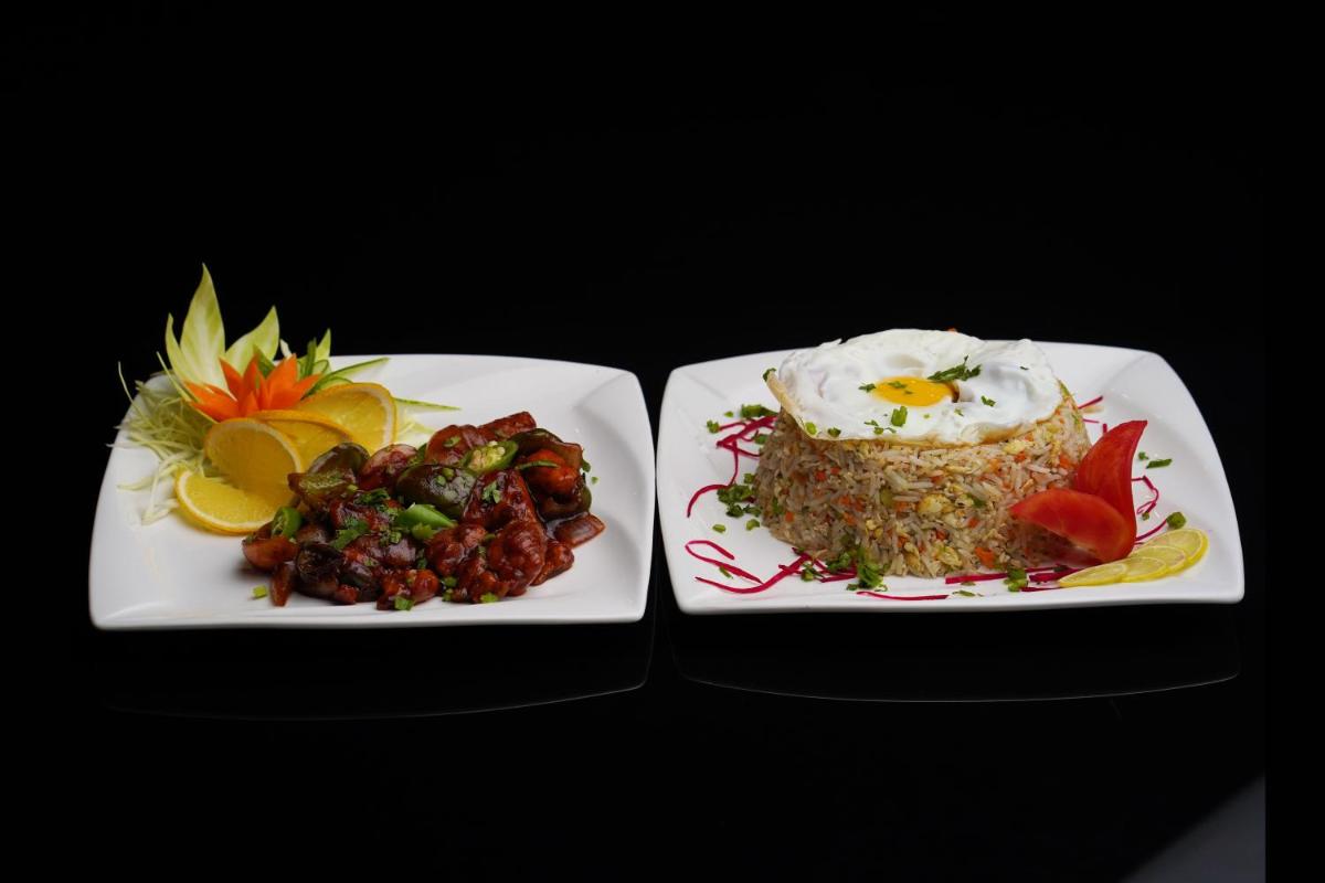 two plates of food with a cake and fruit at Elephant Passage in Munnar