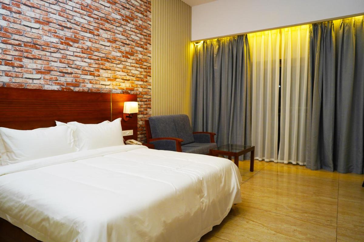 a hotel room with a bed and a chair at Elephant Passage in Munnar