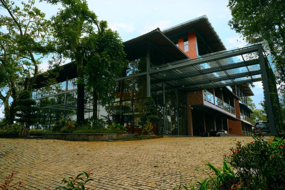 a building with glass windows and a brick courtyard at Elephant Passage in Munnar