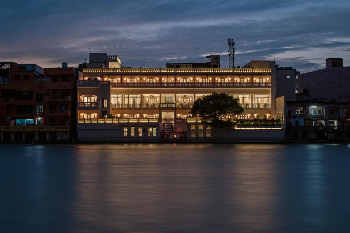 a lit up building next to the water at night at Pilibhit House, Haridwar – IHCL SeleQtions in Haridwār