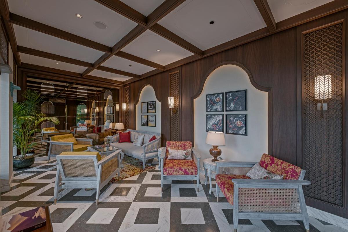 a lobby with chairs and tables in a building at Pilibhit House, Haridwar – IHCL SeleQtions in Haridwār