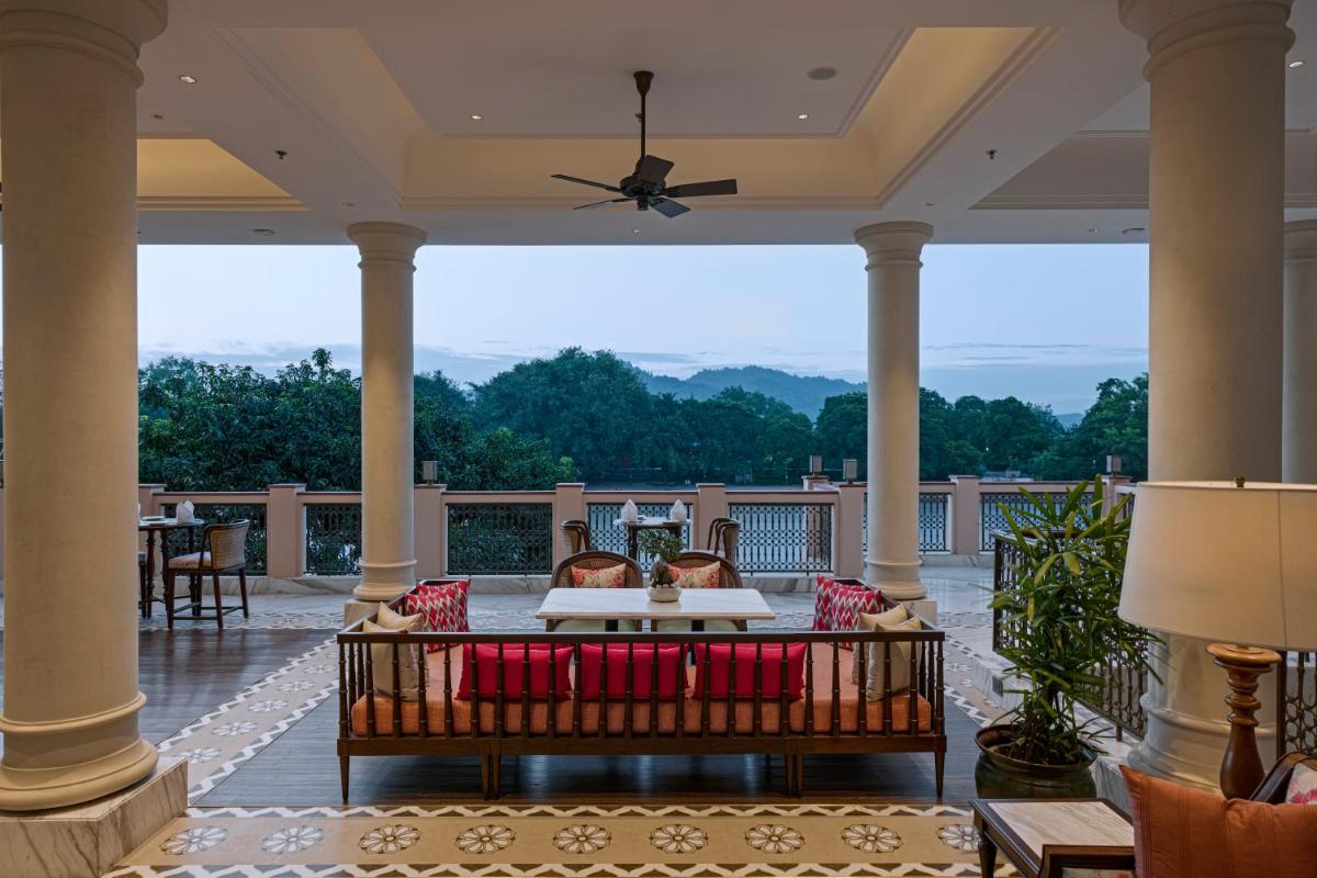 a screened porch with a couch and a table at Pilibhit House, Haridwar – IHCL SeleQtions in Haridwār