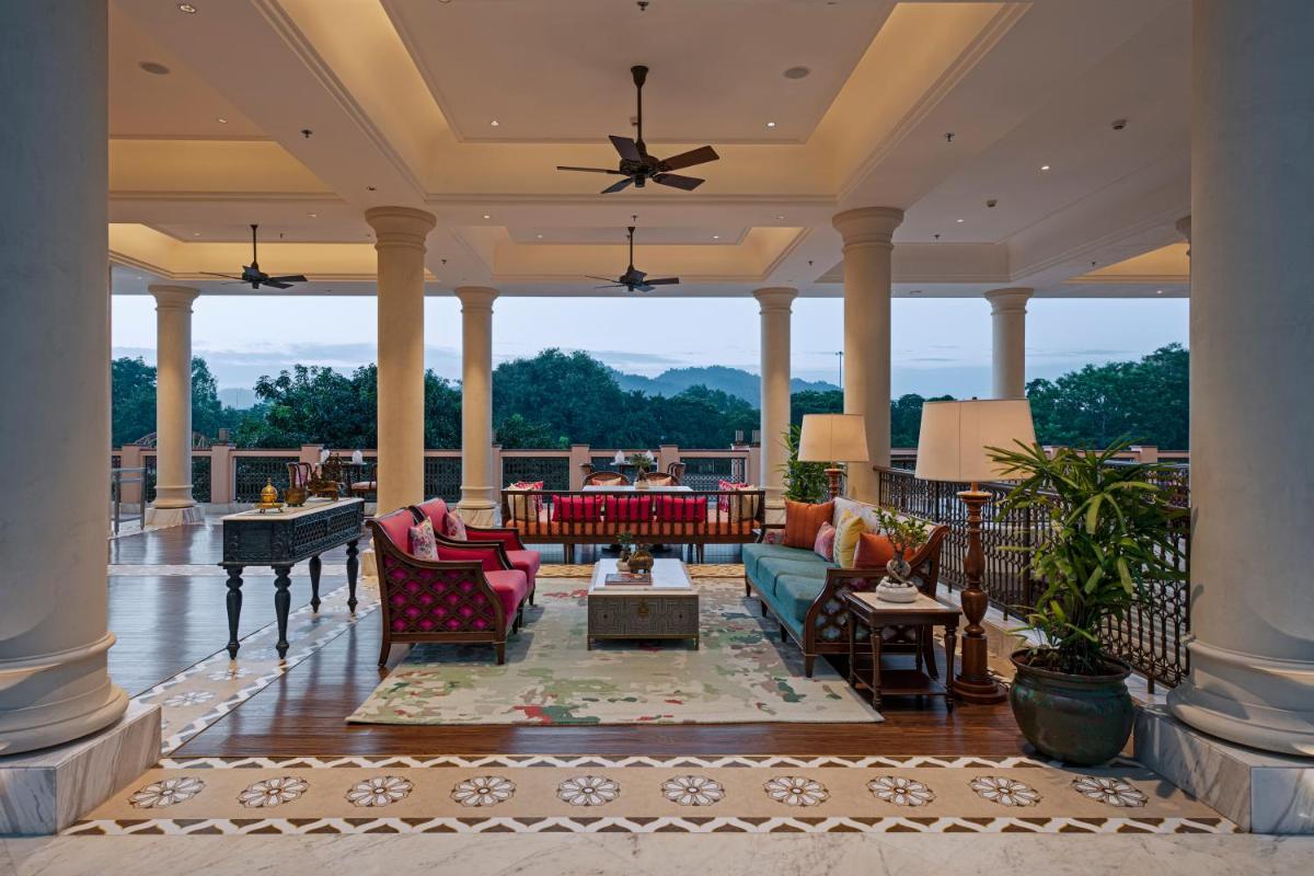 a living room with chairs and tables on a porch at Pilibhit House, Haridwar – IHCL SeleQtions in Haridwār