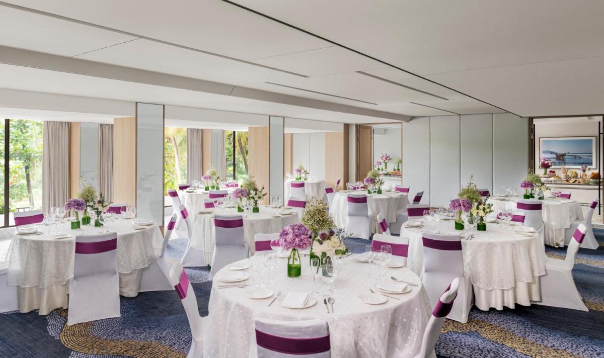 a room with white tables and chairs with flowers on them at Vivanta Goa, Miramar in Panaji +51 photos a room with white tables and chairs with flowers on them at Vivanta Goa, Miramar in Panaji +51 photos