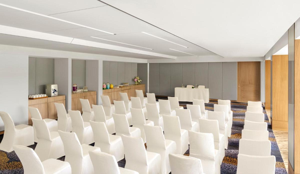 an empty conference room with white chairs in it at Vivanta Goa, Miramar in Panaji an empty conference room with white chairs in it at Vivanta Goa, Miramar in Panaji
