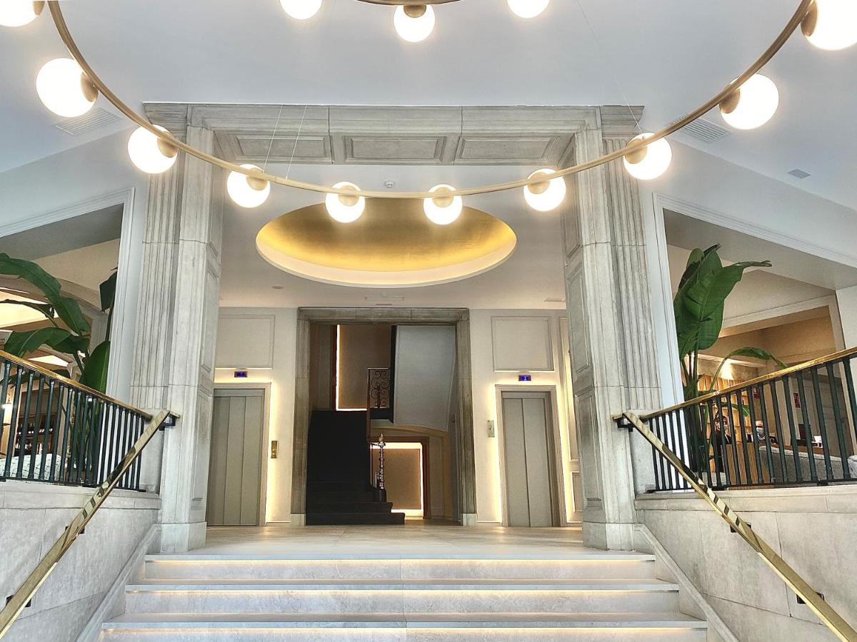 un vestíbulo con escaleras y una gran lámpara de araña en Lamaro Hotel, en Barcelona