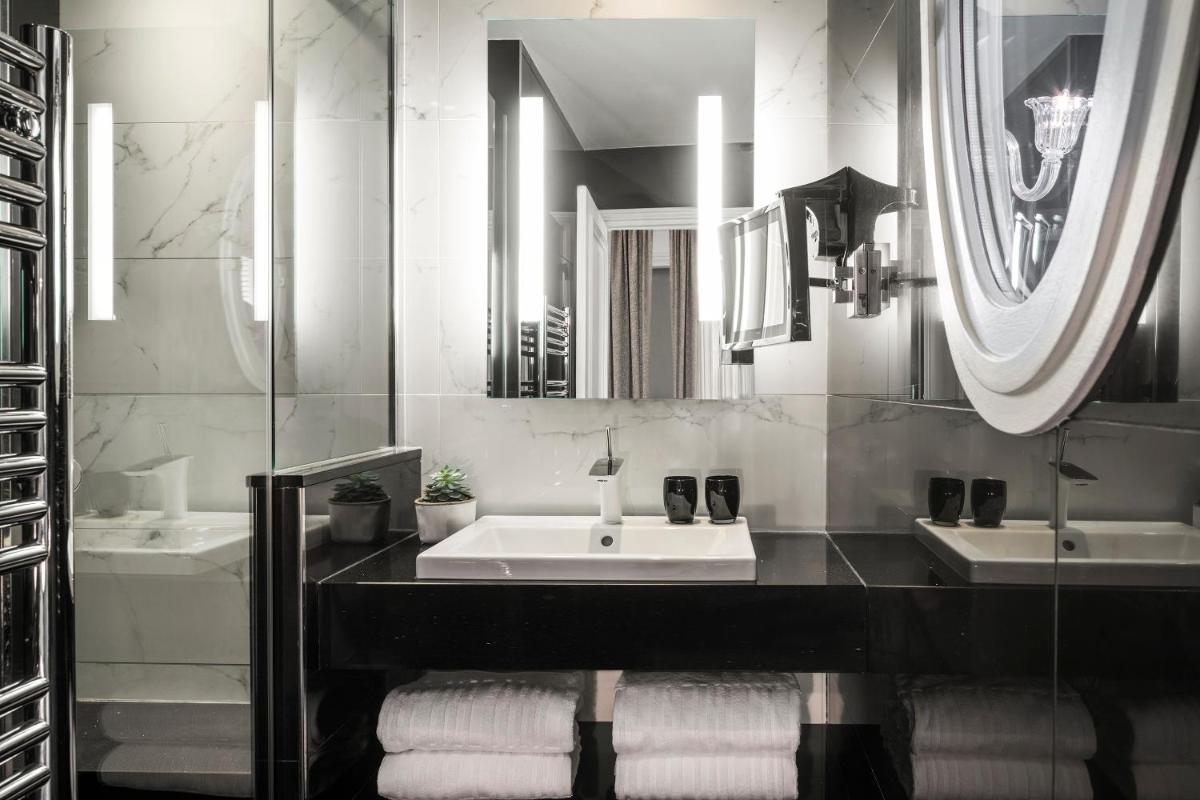 - une salle de bains en noir et blanc avec deux lavabos et des miroirs dans l'établissement Maison Albar- Le Champs-Elysées, à Paris 37 autres photos