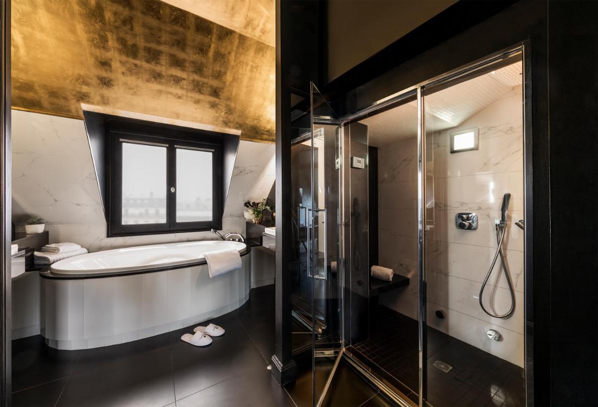une salle de bain avec baignoire et douche dans l'établissement Maison Albar- Le Champs-Elysées, à Paris